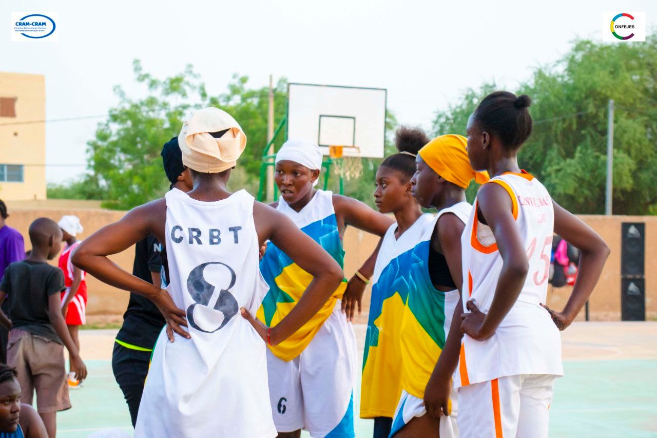 Des joueuses de basket-ball échangent au bord du terrain.