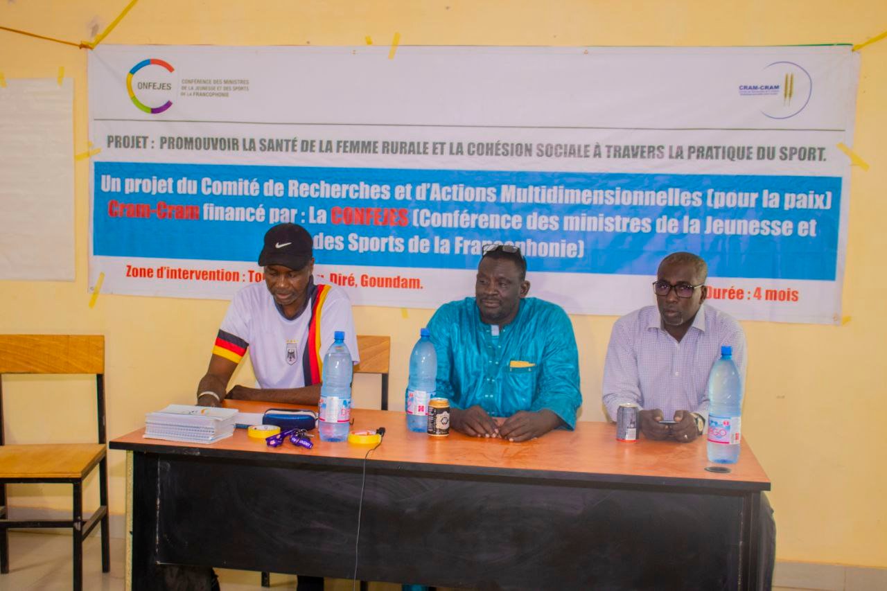 Des intervenants présentent le projet devant sa banderole.