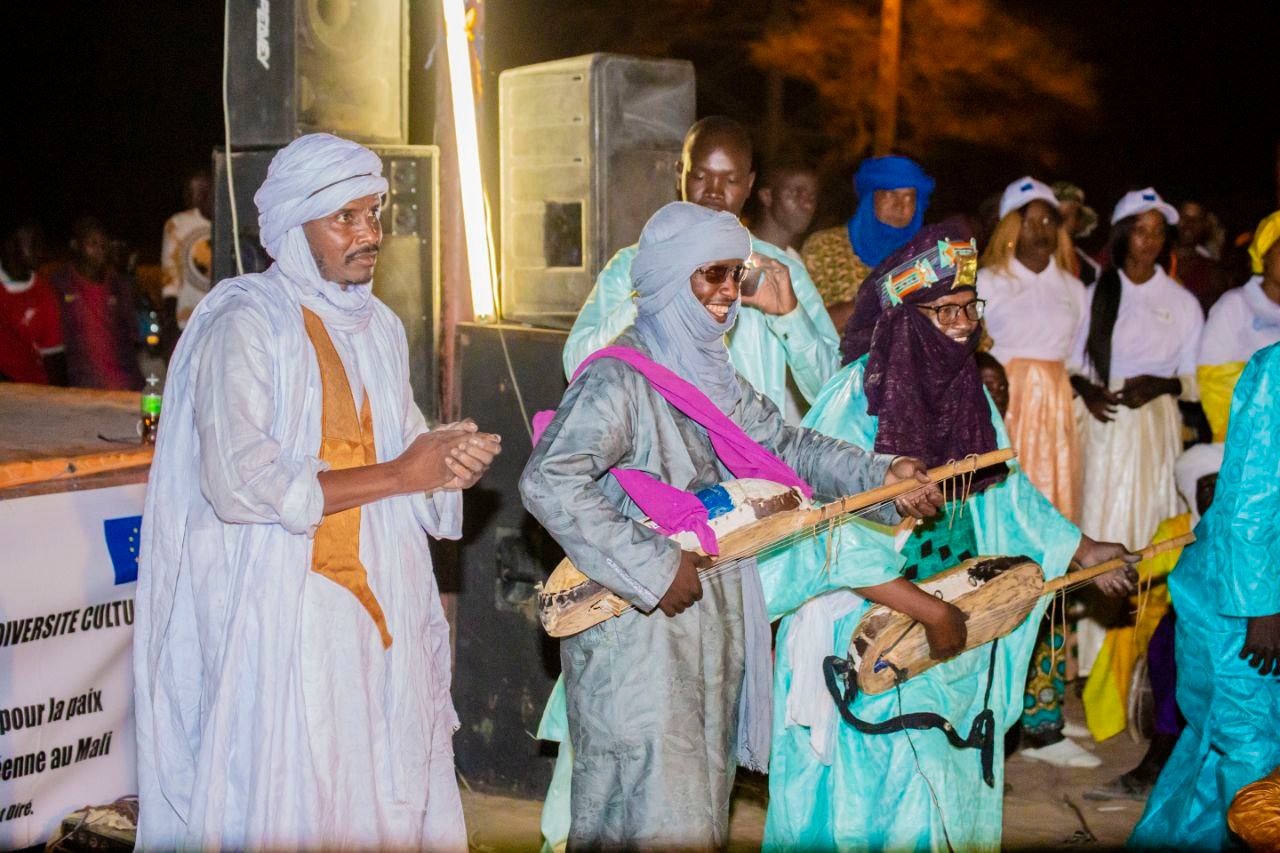 Des musiciens en tenue traditionnelle jouent d’instruments à cordes.