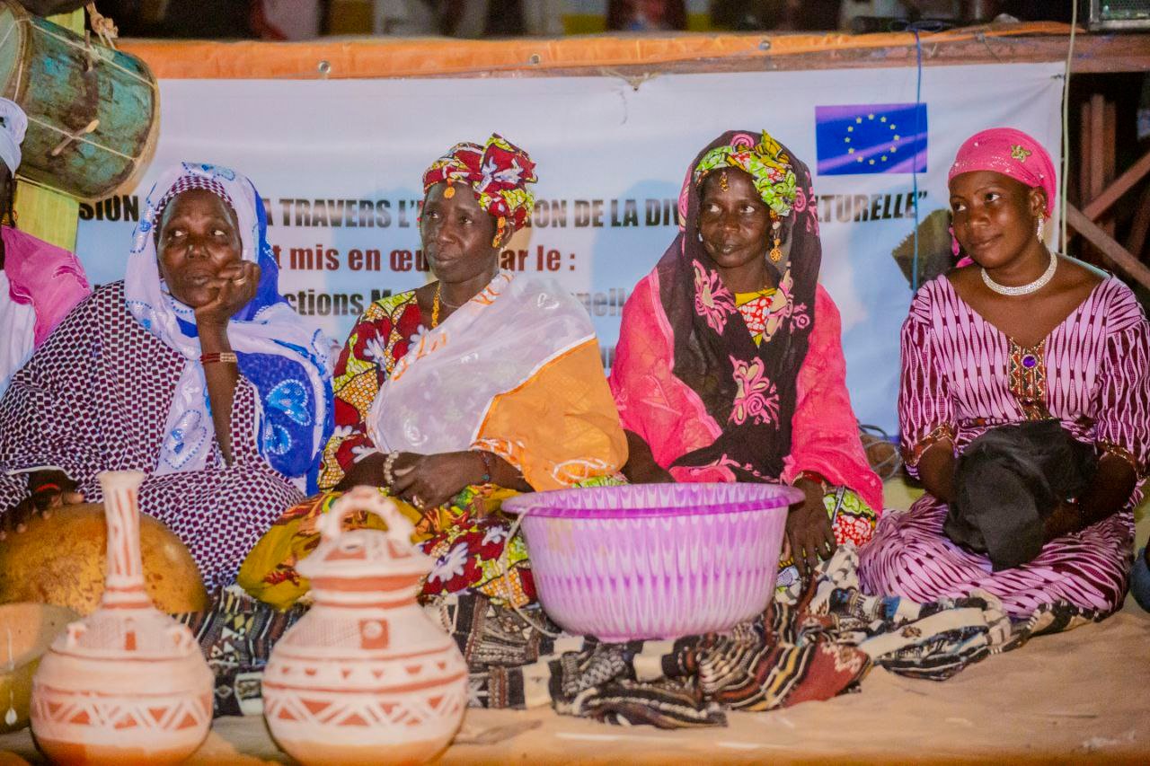 Des femmes présentent des poteries et des objets traditionnels.